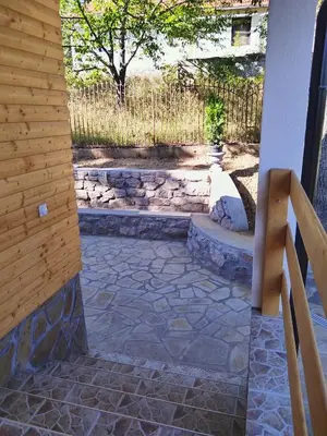 a stone walkway leading to a patio with a fence at Stari Hrast 2 in Prolomska Banja