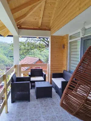 a patio with couches and chairs on a porch at Stari Hrast 2 in Prolomska Banja