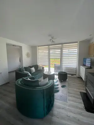 a living room with green couches and a couch at Stari Hrast 2 in Prolomska Banja