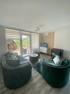 a living room with two couches and a tv at Stari Hrast 2 in Prolomska Banja