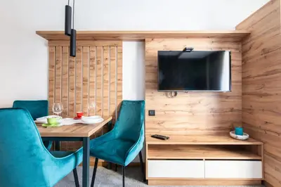 a dining room with a table and chairs and a tv at Lux studio Andrej A43 Hotel Djina in Kopaonik