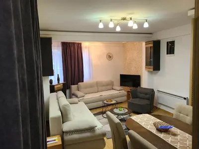 a living room with a couch and a table at Apartman B 8 - Lapčević u zgradi MUJEN LUX, Kopaonik in Kopaonik