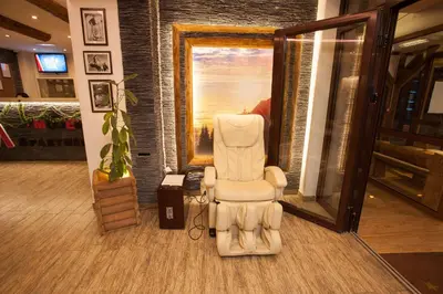 a white chair sitting in the middle of a room at Apartman B 8 - Lapčević u zgradi MUJEN LUX, Kopaonik in Kopaonik