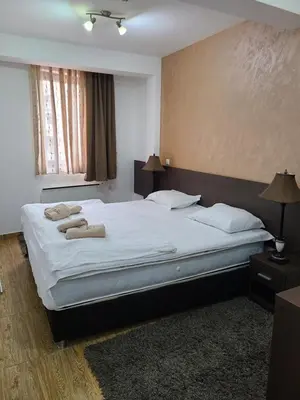 a bedroom with a large bed with towels on it at Apartman B 8 - Lapčević u zgradi MUJEN LUX, Kopaonik in Kopaonik