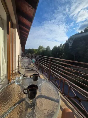 a table on a balcony with two cups on it at Kopaonik Milmari & Spa N Lux 90 in Kopaonik