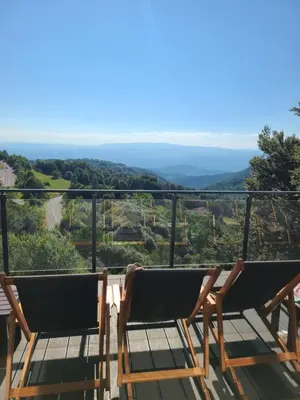 a balcony with two chairs and a view of the mountains at Kopaonik Milmari & Spa N Lux 90 in Kopaonik