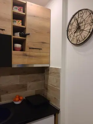 a clock hanging on a wall next to a kitchen at Kopaonik Milmari & Spa N Lux 90 in Kopaonik
