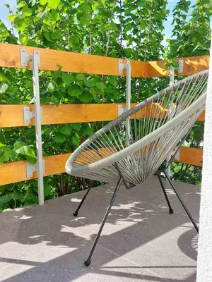 a metal bench sitting next to a wooden fence at Apartman Krinka in Vrnjačka Banja