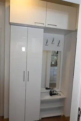a closet with white cabinets and a mirror at Apartman Krinka in Vrnjačka Banja