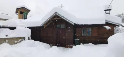 a cabin in the snow with snow piled up at Konak Šarac in Crni Vrh