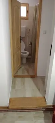 a bathroom with a toilet and a door in a room at Konak Šarac in Crni Vrh