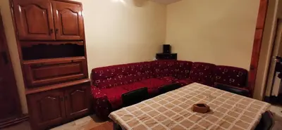 a room with a table and a red couch and a table and a table at Konak Šarac in Crni Vrh