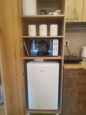 a microwave sitting on top of a refrigerator in a kitchen at Golden Mountain A75 NLux Milmari in Kopaonik