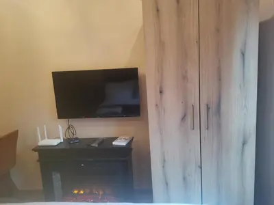 a living room with a television and a fireplace at Golden Mountain A75 NLux Milmari in Kopaonik