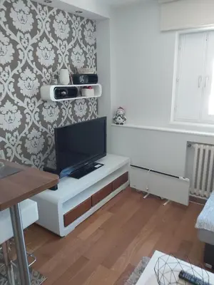 a living room with a tv on a white cabinet at MR. O Apartments Kopaonik in Kopaonik
