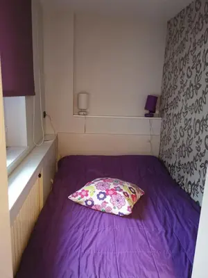 a bed in a small room with a pillow on it at MR. O Apartments Kopaonik in Kopaonik