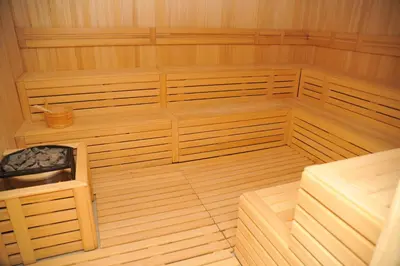 an empty sauna with wooden floors and a chair at Apartman A20B in Kopaonik