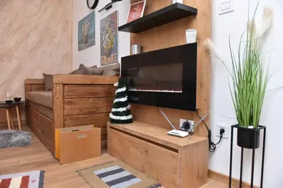 a living room with a flat screen tv and a couch at Start Apartments LUX KOPAONIK in Kopaonik