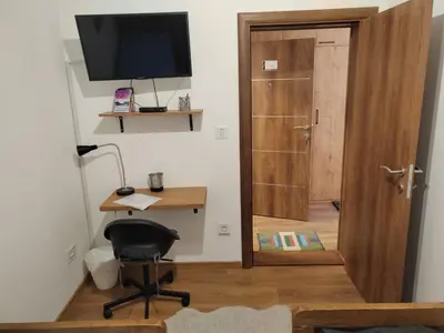a room with a desk and a chair and a television at Start Apartments LUX KOPAONIK in Kopaonik