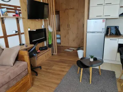 a living room with a couch and a refrigerator at Start Apartments LUX KOPAONIK in Kopaonik
