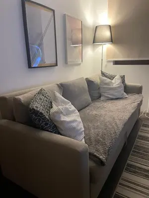 a couch in a living room with pillows on it at Sunčani Breg Resort&Spa Kopaonik, Apartman broj 409 in Kopaonik