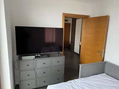 a bedroom with a dresser with a television on it at Sunčani Breg Resort&Spa Kopaonik, Apartman broj 409 in Kopaonik
