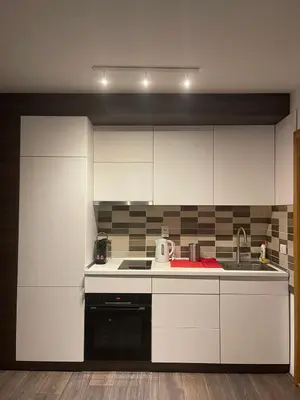 a kitchen with white cabinets and a sink at Sunčani Breg Resort&Spa Kopaonik, Apartman broj 409 in Kopaonik