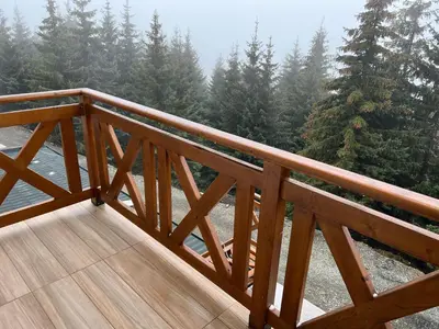 a wooden deck with trees in the background at Sunčani Breg Resort&Spa Kopaonik, Apartman broj 409 in Kopaonik