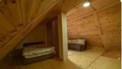 a room with two beds in a wooden attic at Apartmani Moskva in Kopaonik