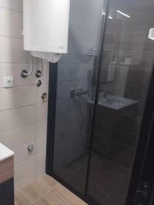 a bathroom with a glass shower with a sink at Sunčana Planina Kopaonik in Kopaonik