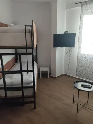 a bedroom with two bunk beds and a table at Sunčana Planina Kopaonik in Kopaonik