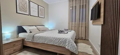 a small bedroom with a bed and a television at Apartman Vukota 2 Pirot in Pirot