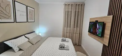 a bedroom with a bed with a tv on the wall at Apartman Vukota 2 Pirot in Pirot
