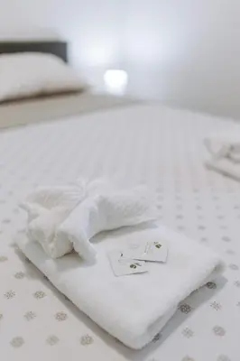 a pile of white towels sitting on a bed at Apartman Vukota 2 Pirot in Pirot