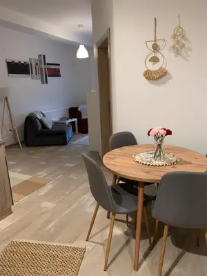 a dining room table and chairs in a living room at Apartman-Stefanovic in Vranje