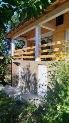 a house with a balcony on the side of it at Stari Hrast 1 in Prolomska Banja
