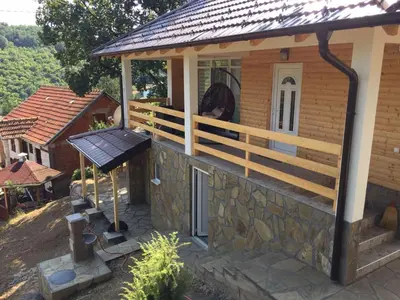 a large building with a deck and a grill at Stari Hrast 1 in Prolomska Banja