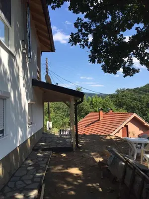 a building with a porch and a bench next to it at Stari Hrast 1 in Prolomska Banja