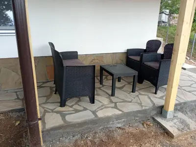 a group of chairs and a table on a patio at Stari Hrast 1 in Prolomska Banja