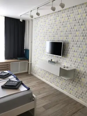 a bedroom with a tv on a tiled wall at Apartman Relax in Niš