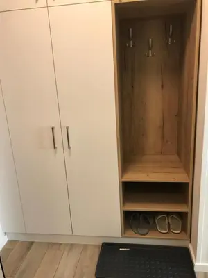 a closet with white cabinets and a treadmill at Apartman Relax in Niš