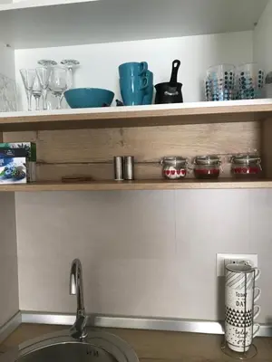 a kitchen shelf with bowls and dishes on it at Apartman Relax in Niš