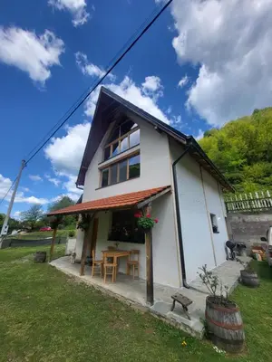 a small white house with a table in a yard at Antić apartmani Stara planina in Crni Vrh