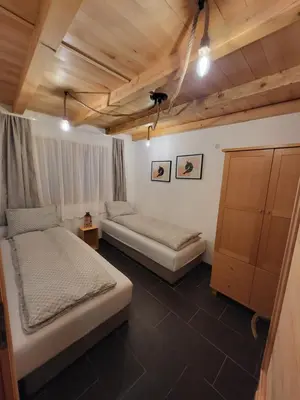 a bedroom with two beds in a room with wooden ceilings at Antić apartmani Stara planina in Crni Vrh