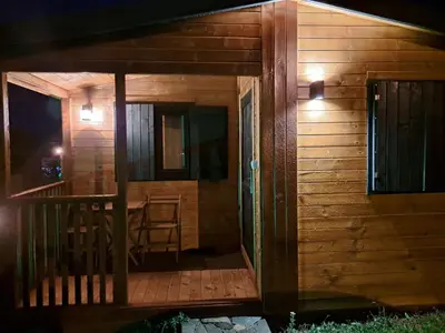 a wooden cabin with a deck with a table at MERAK STD in Vranje