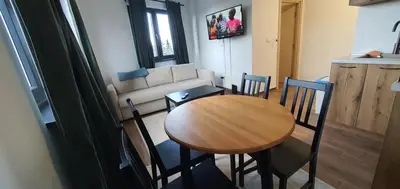 a living room with a wooden table and chairs at MONTANA apartment 21 in Kopaonik