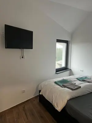 a bedroom with a bed with a flat screen tv on the wall at MONTANA apartment 21 in Kopaonik