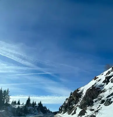 a road covered in snow next to a mountain at MONTANA apartment 21 in Kopaonik