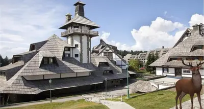 a building with a deer standing in front of it at Angella Kopaonik in Kopaonik