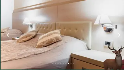 a bedroom with a bed with a deer standing next to it at Angella Kopaonik in Kopaonik